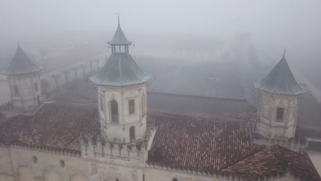 drone flying over chateau cos d'estournel winery on foggy day, bordeaux region of france