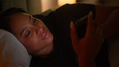 mujer usando teléfono inteligente en la cama por la noche