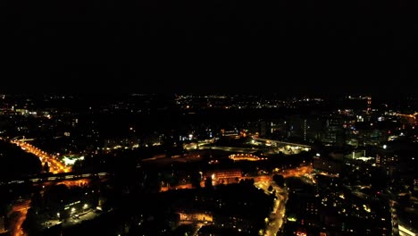 A-smooth,-approaching-aerial-shot-on-Helinski,-Finland-as-a-train-passes-through-the-city-in-the-distance