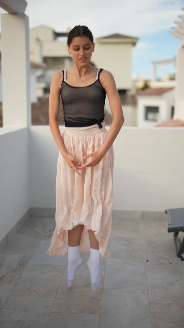 십대 발레리나 가 테라스 에서 연습 하고 있다