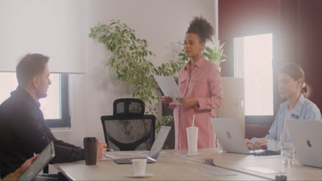 pregnant woman explaining a project in front of her coworkers in a meeting room 5