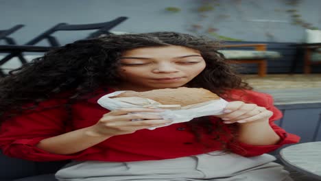mujer comiendo un sándwich al aire libre