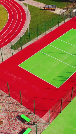 modern sports grounds. flight over colorful stadiums with nobody. modern fields for playing different sport outdoors. vertical video