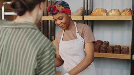 beautiful black woman selling fresh bread in bakery