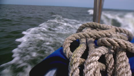 view from the stern of a sailboat while sailing at sea on a sunny day, copy space