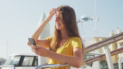 Vista-Lateral-De-Una-Adolescente-Caucásica-Disfrutando-De-Su-Tiempo-En-Un-Barco-Y-Usando-Su-Teléfono