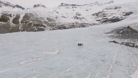 aerial panoramic landscape view over people hiking on the ice surface of virkisjokull glacier, iceland