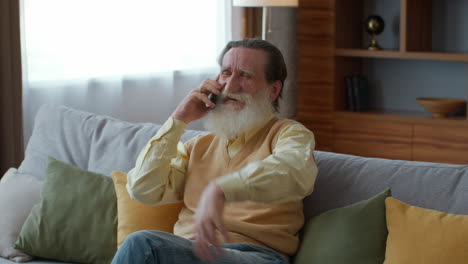 senior man talking on phone at home