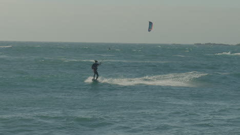 male enjoying kite surfer riding wave off coast of matanzas, chile. tracking shot