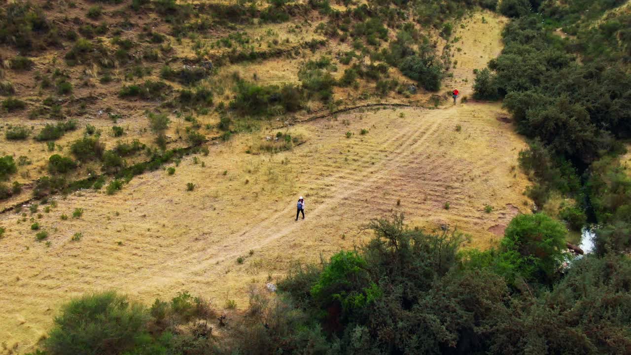 Escursionisti camminano attraverso una valle aperta sul sentiero per Inkilltambo, Cusco, Perù