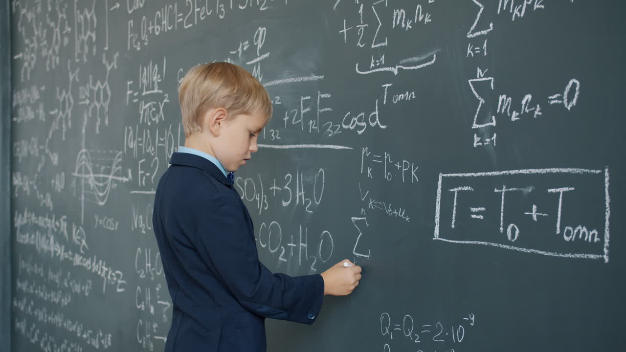 Young Boy Writing Equations on a Chalkboard
