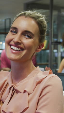 portrait of caucasian businesswoman smiling over diverse business colleagues talking