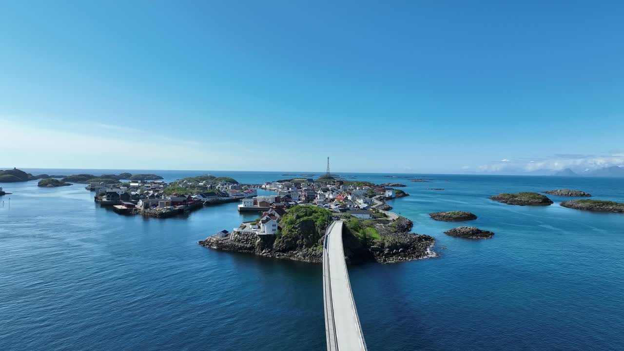 Henningsvaer bridge with traffic leading into the village islands and ocean horizon on sunny day