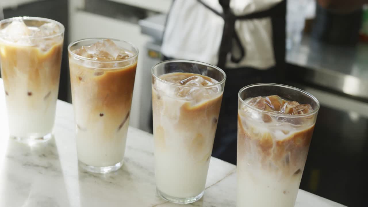 Mid section of african american male cafe owner and biracial female barista making coffe at cafe