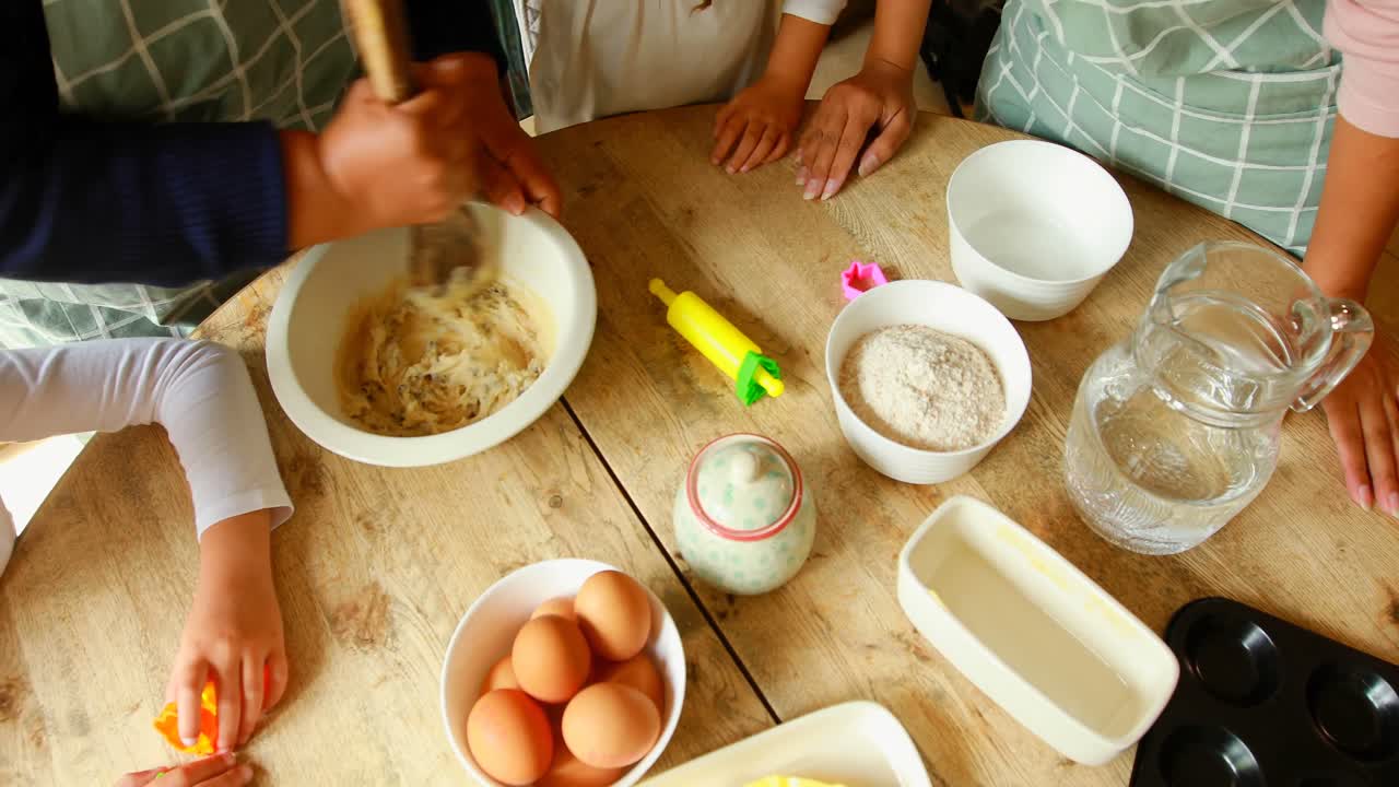 Siblings preparing food with family in kitchen 4k