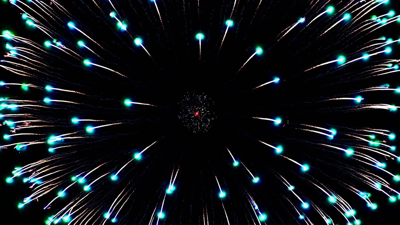 Aerial view of a vibrant firework burst against a black sky, captured in a video