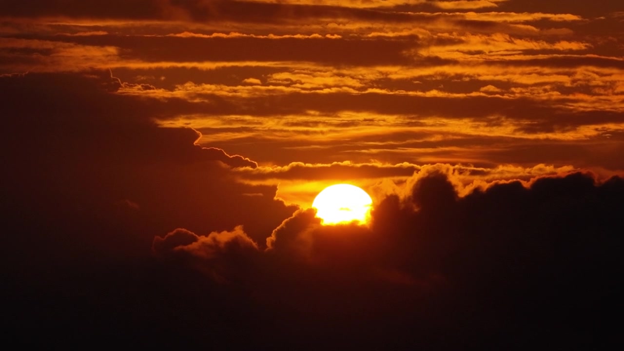 Drohnenansicht des Sonnenuntergangs hinter glühenden orangefarbenen Wolken über dem Meer, Kreta, Griechenland