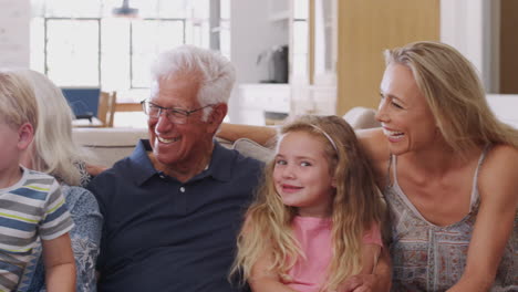 portrait of multi-generation family sitting on sofa at home
