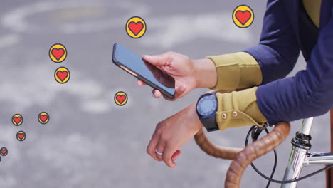 múltiples iconos de corazón flotando contra la sección media de la mujer con bicicleta usando un teléfono inteligente