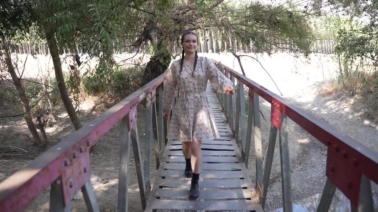 Una giovane donna si gode una bella esperienza mentre esplora un ponte immersa nell'abbraccio della natura.