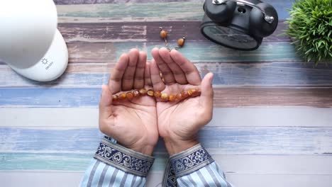 muslim man keep hand in praying gestures during ramadan, close up