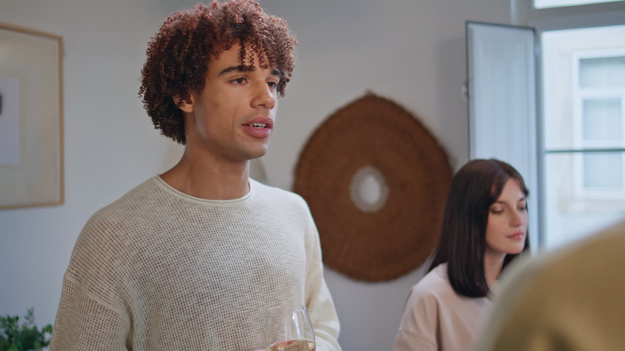Curly youngster taking snack drinking wine at home closeup. Relaxed teenagers