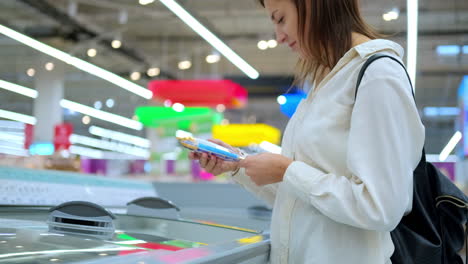 mujer eligiendo comida congelada en el supermercado
