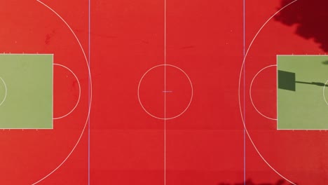 Bright symmetrical sports field with faint moving shadows on sunny surface