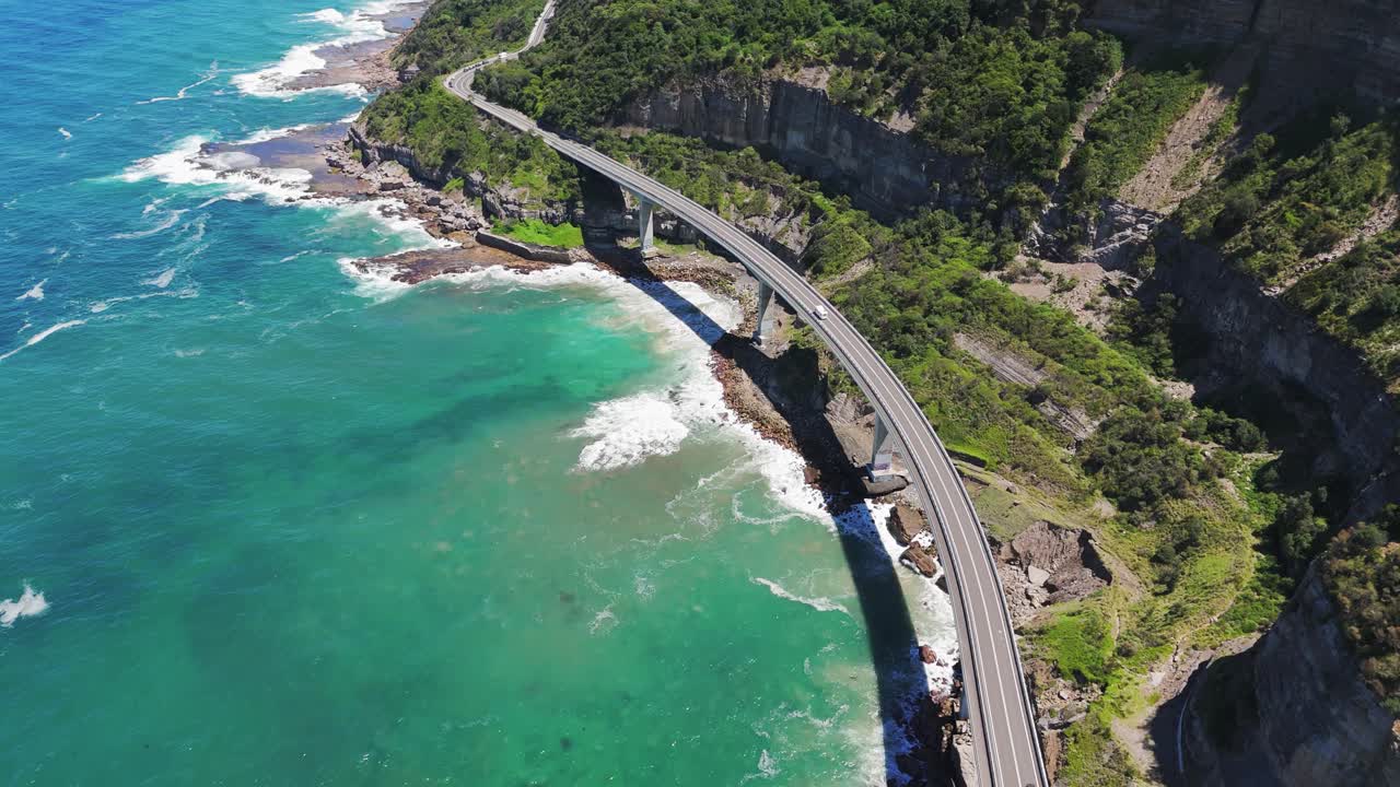 Aerial view of Sea Cliff Bridge during the day on Lawrence Hargrave drive to Wollongong in the region of New South Wales, Australia, establishing drone shot