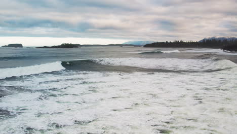 surfers in water trying to catch waves at cox bay beach, tofino