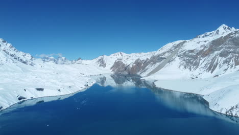 Blue-Tilicho-Lake-in-Manang-Nepal-is-surrounded-by-Mountains-covered-with-snow