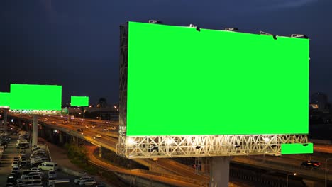 green screen of advertising billboard on expressway during the twilight with city background in bangkok, thailand.