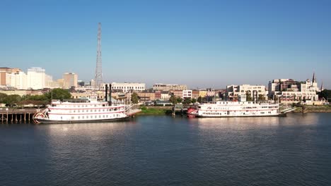 un avión no tripulado vuela sobre barcos de vapor anclados a lo largo de la costa del río mississippi de nueva orleans