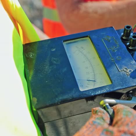 Industrial device in worker's hands. Technician holds special equipment during building. Engineering works. Close-up.