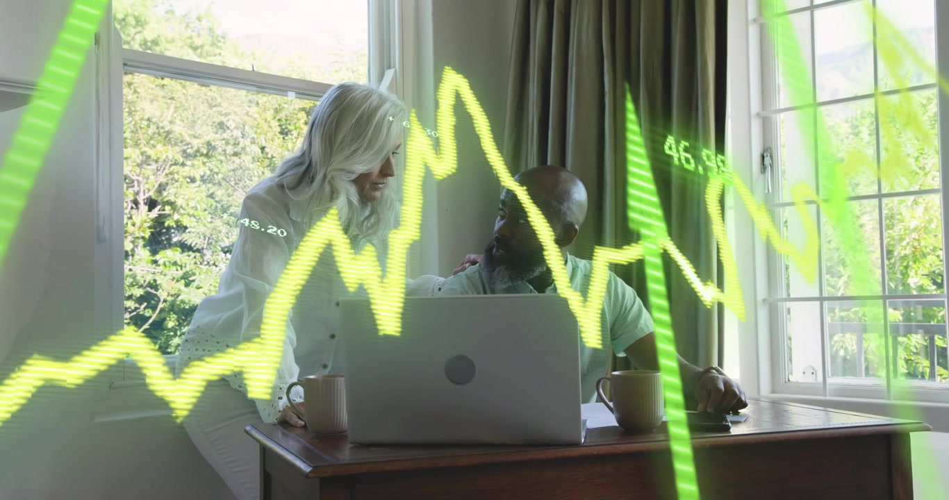Stigende grafisk overlay, rådgiver læner sig over kollega og peger på bærbar computer, mens han guider gennem finansdata.