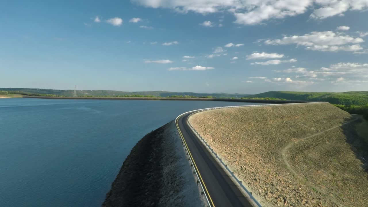 Aerial flying along road at Raccoon Mountain reservoir with cinematic slow tilt up to horizon