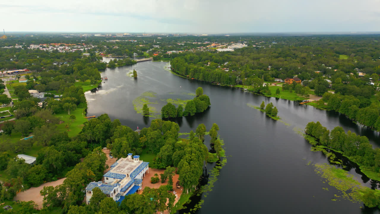 Luftdolly over frodige våtmarker langs elven nær Tampa, Florida, med rolig vann og trær som beskytter hus