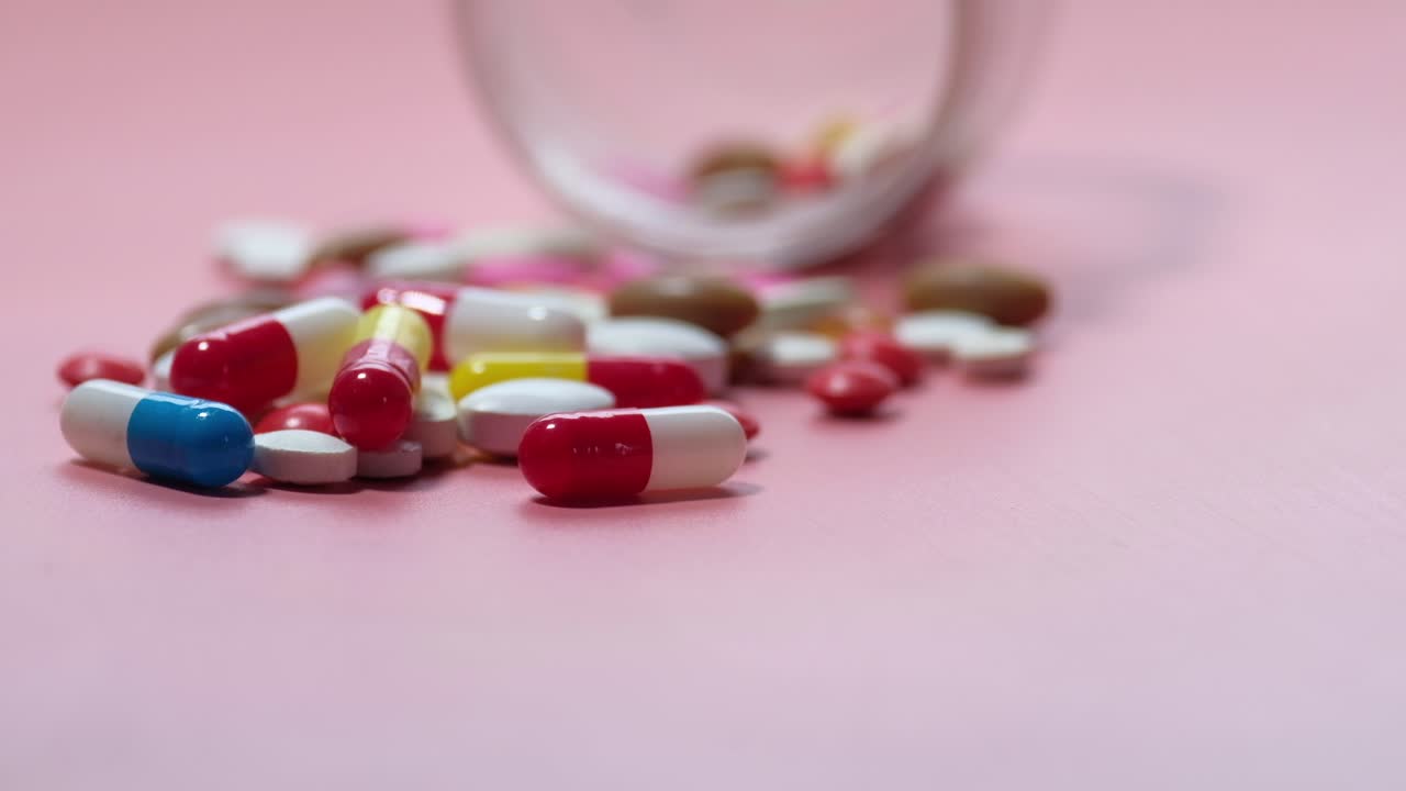 pastillas y cápsulas variadas en superficie rosada