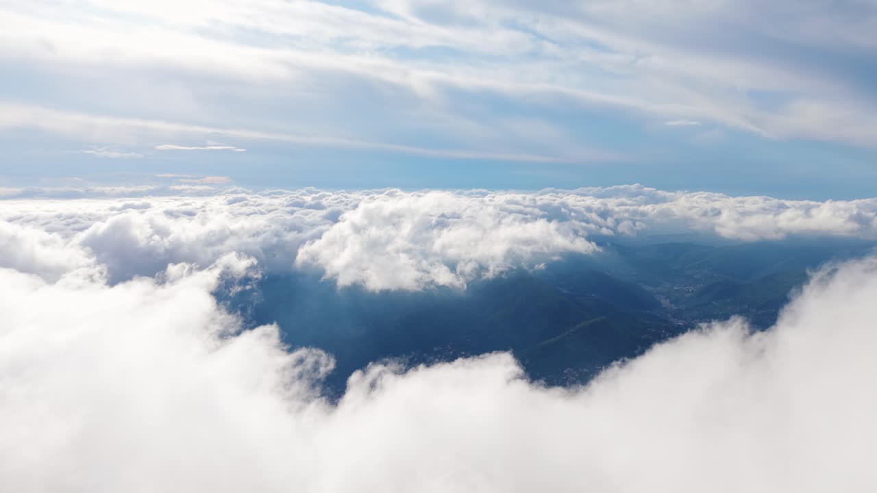 Clouds above mountains, showcasing a serene landscape of nature, aerial view