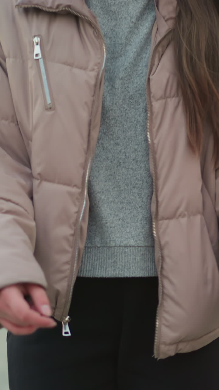 Close-up shot focusing on the legs of a girl wearing black trousers and a peach jacket as she rolls on rollerblades through an urban park path. the smooth motion and urban environment