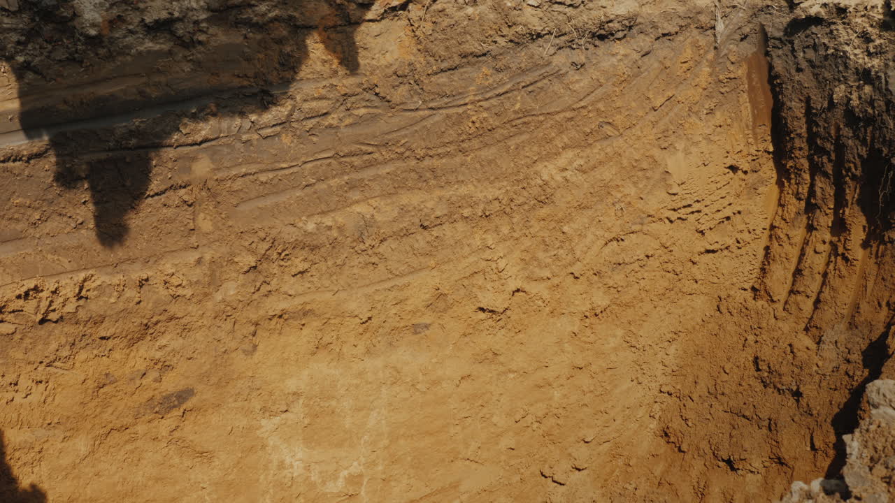 cucharón de excavadora extrae tierra de una zanja profunda