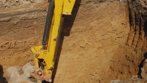 Excavator-Bucket-Extracts-Ground-From-Deep-Trench