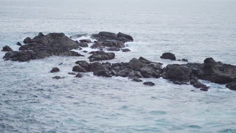 calmantes olas azules que se estrellan contra la formación rocosa en el mar