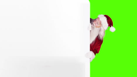 santa espiando alrededor de la tarjeta de regalo en el fondo de la pantalla verde