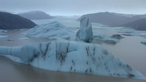 Toma-Aérea-Baja-Y-Lenta-A-Través-De-Icebergs-Hacia-Un-Gran-Glaciar