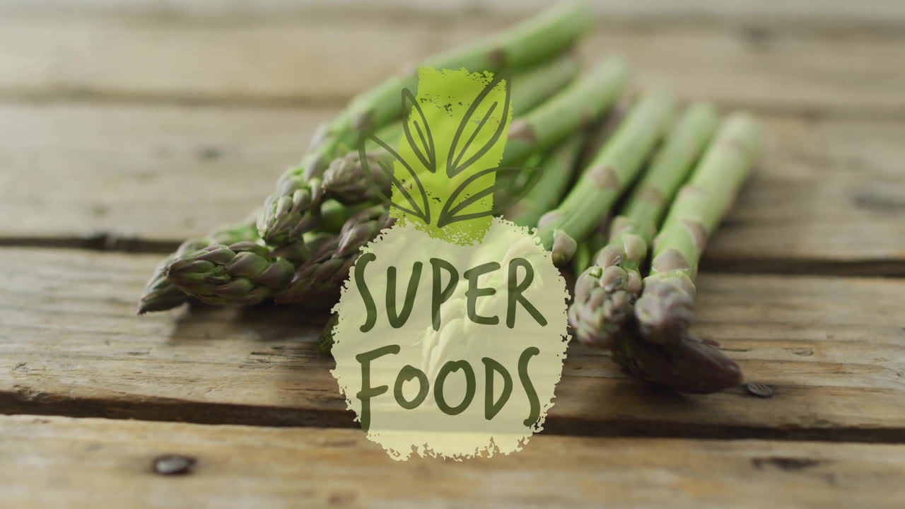 Super foods text animation over asparagus on wooden surface