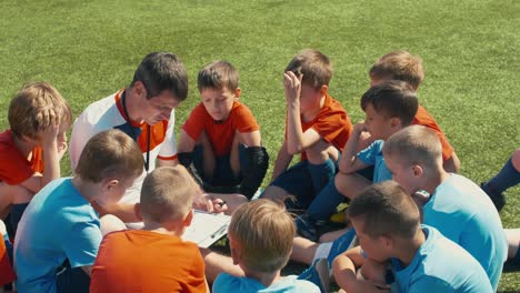 young soccer players listening to coach