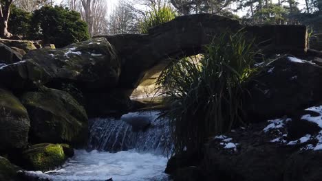flowing cascading waterfall on the river wandle in beddington park, london