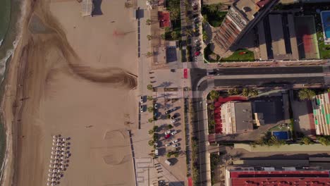 Beach-Sunbeds-And-Beachfront-Resorts-In-San-Juan-at-dawn,-Alicante,-Spain