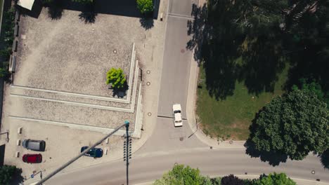 Un-Automóvil-Circulando-Por-Un-Tranquilo-Barrio-Suburbano,-árboles-Que-Proyectan-Sombras,-Vista-Aérea